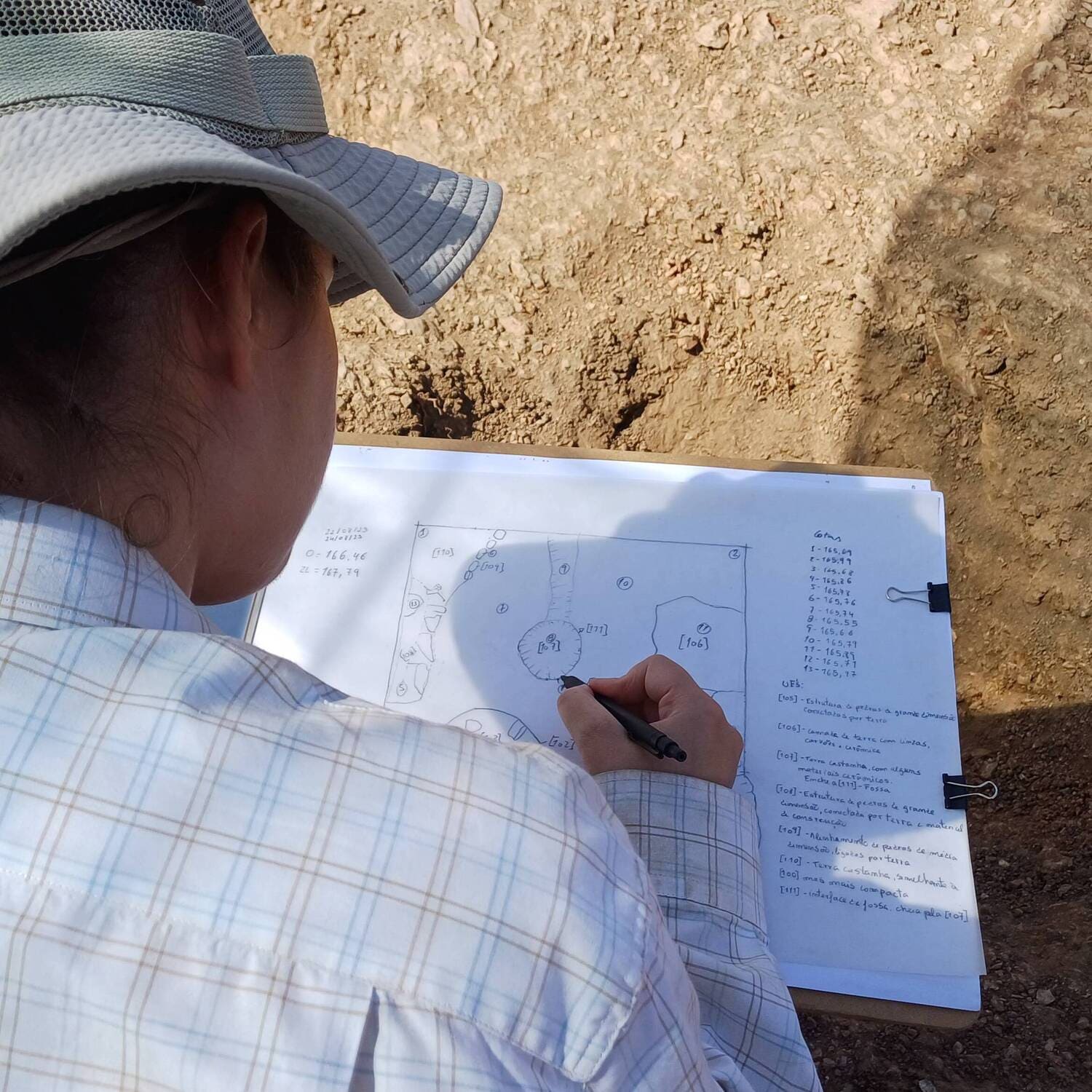 Arqueóloga desenha e documenta pormenores da escavação, garantindo a precisão científica do registo arqueológico.